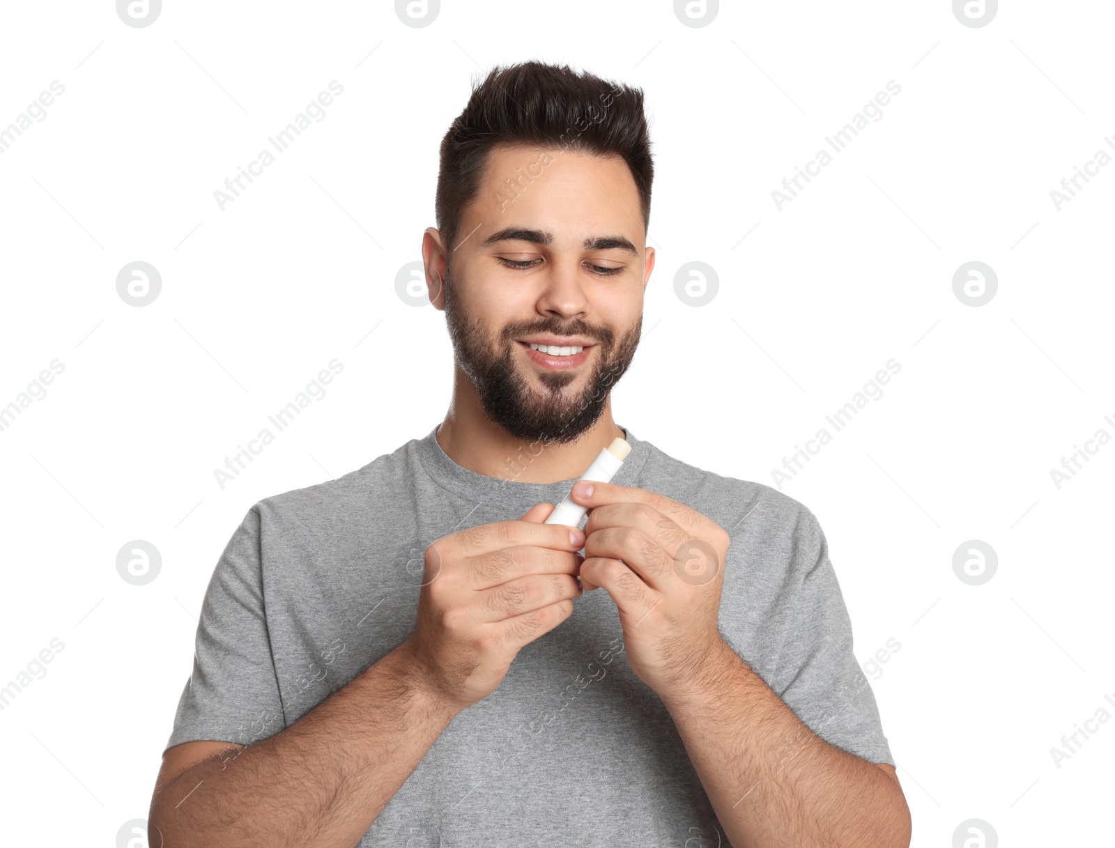 Photo of Young man with lip balm on white background