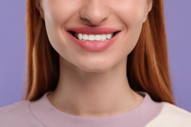 Photo of Woman with clean teeth smiling on violet background, closeup