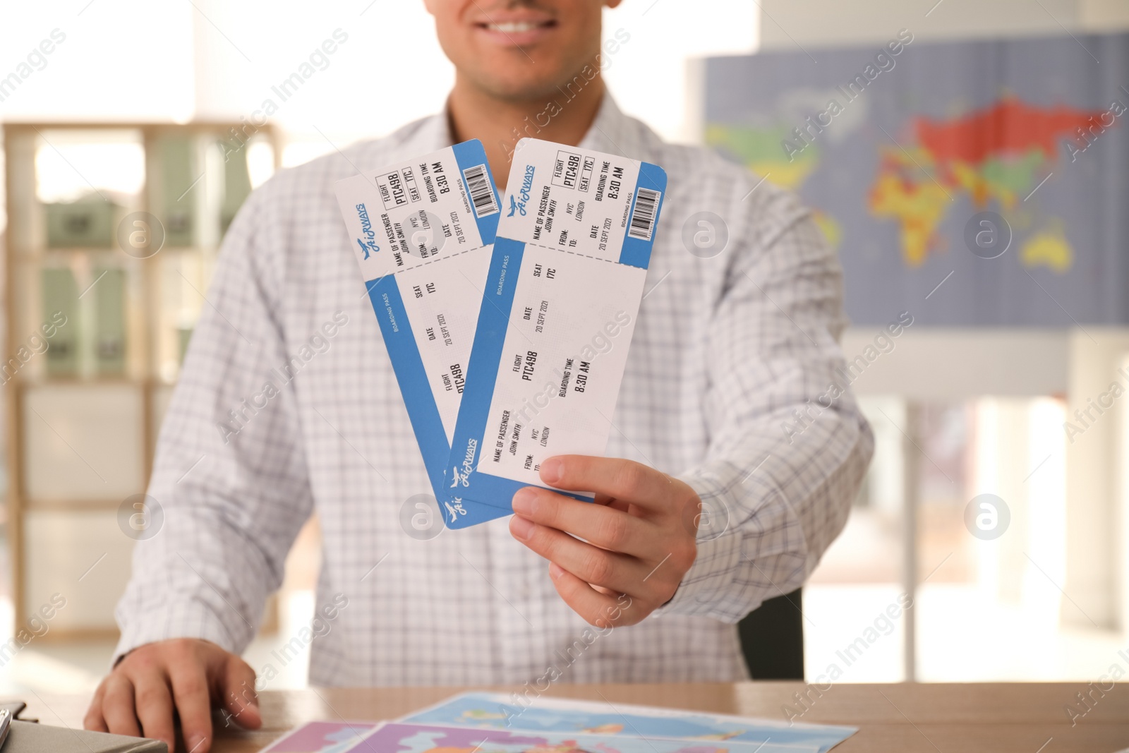 Photo of Travel agent with tickets at table in office, closeup