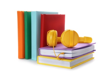 Modern headphones with hardcover books on white background