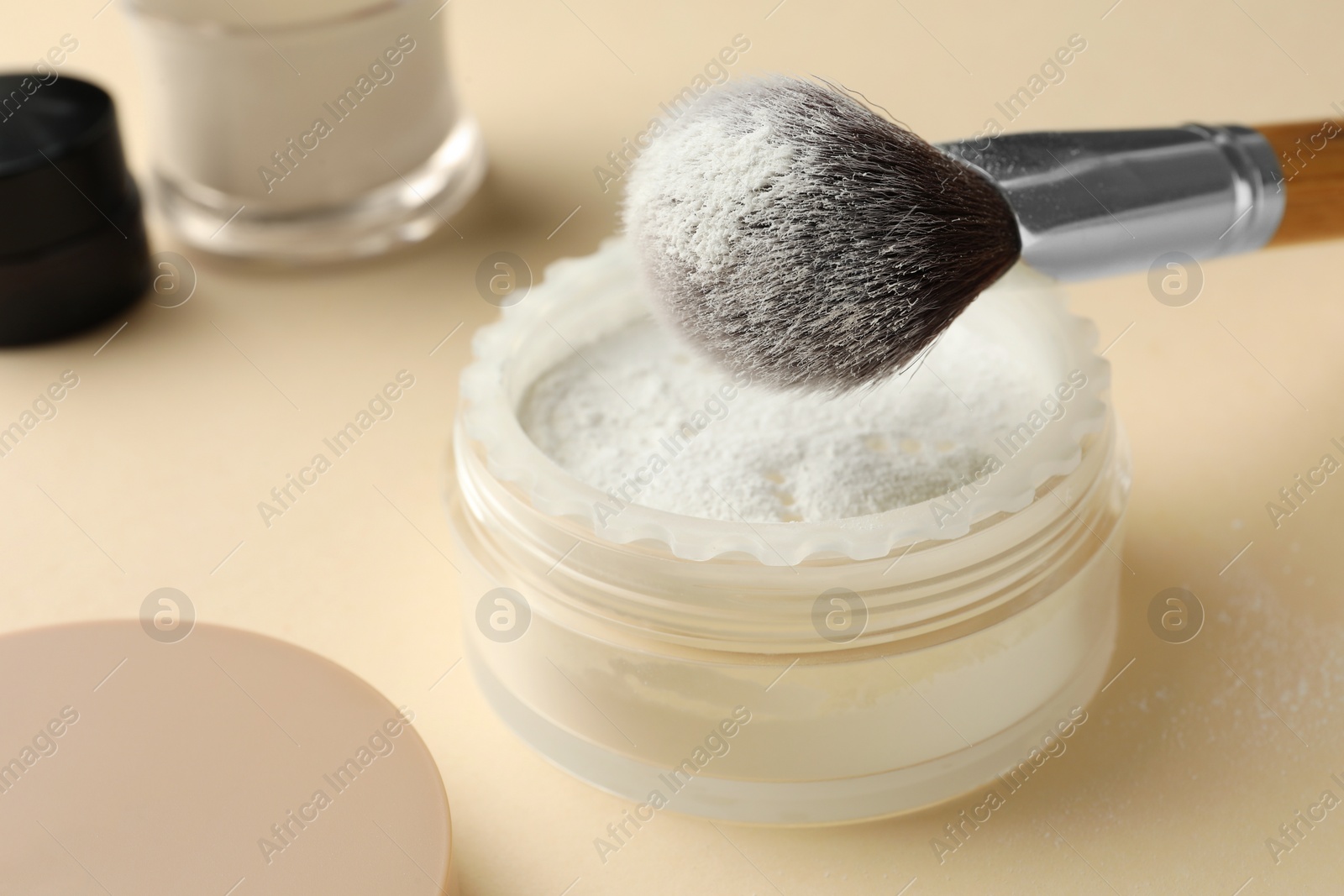 Photo of Makeup brush with rice loose face powder on beige background, closeup. Space for text