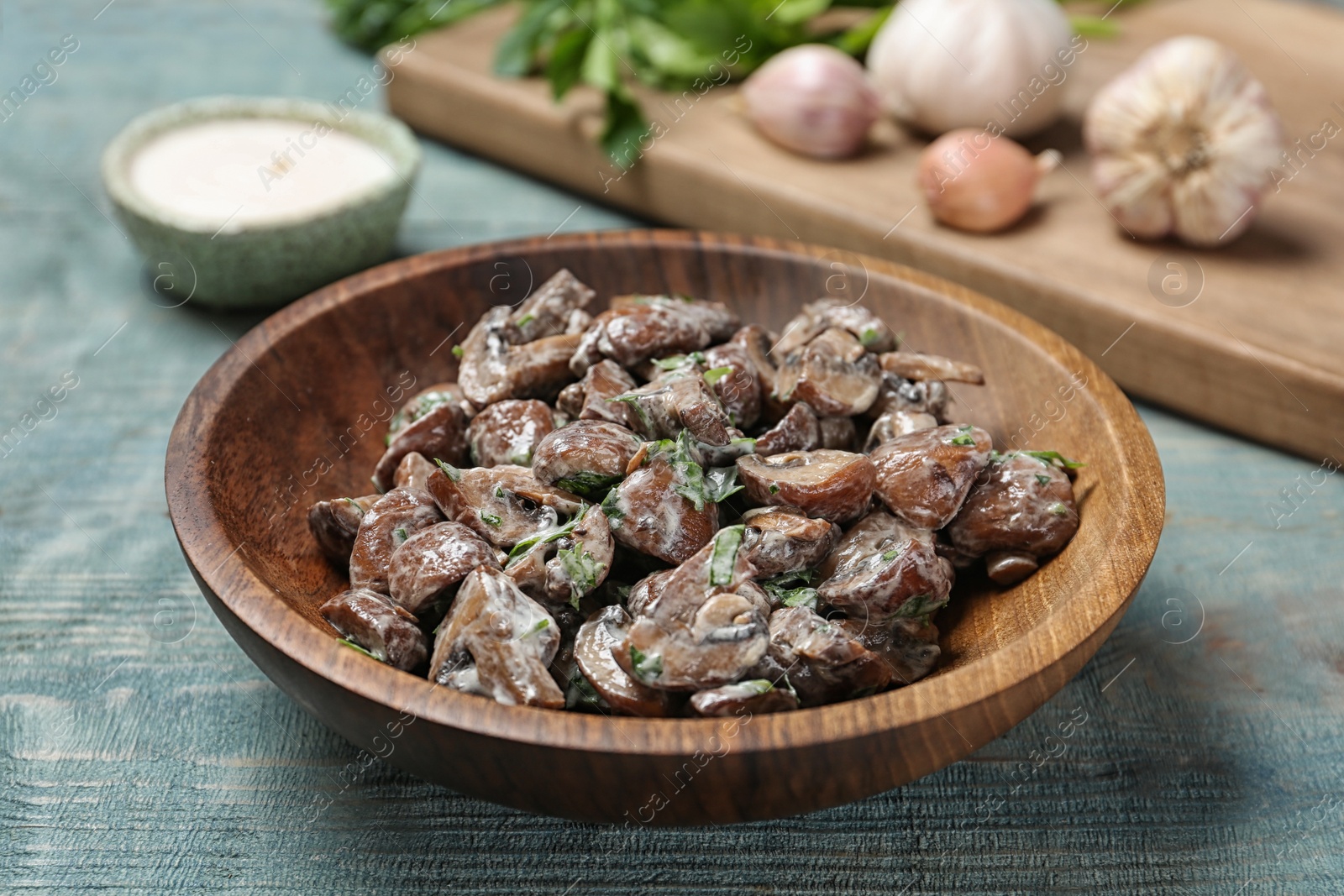 Photo of Bowl of fried mushrooms with sauce on table