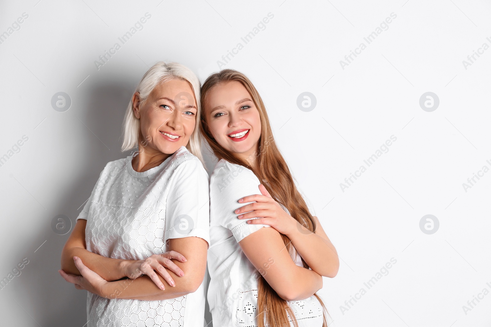 Photo of Mother and her adult daughter on white background. Space for text