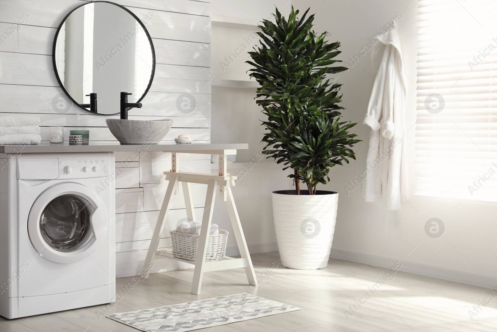 Photo of Stylish bathroom interior with modern washing machine