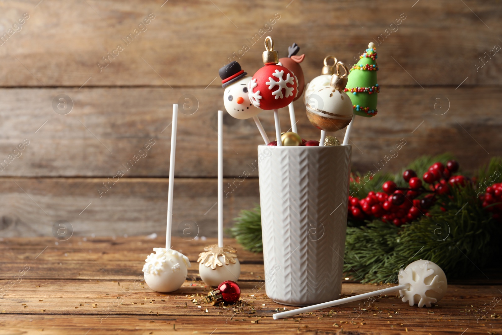 Photo of Delicious Christmas themed cake pops on wooden table. Space for text