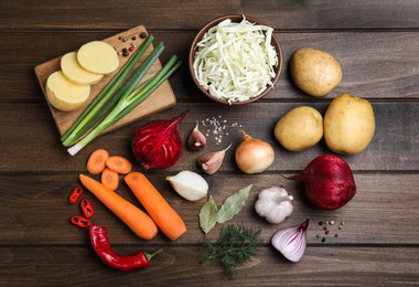 Photo of Fresh ingredients for borscht on wooden table, flat lay