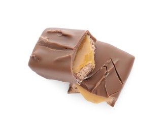 Pieces of chocolate bar with caramel on white background, top view