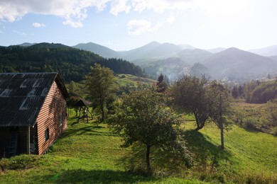 Photo of Beautiful landscape with wooden house in mountains on sunny day