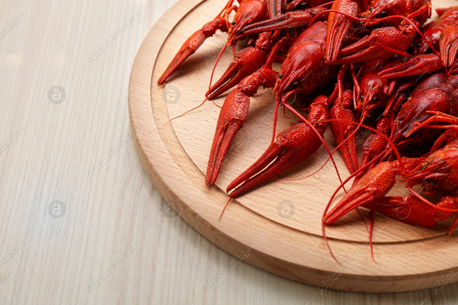 Photo of Delicious red boiled crayfish on white wooden table