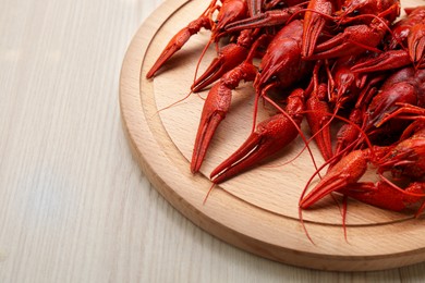 Photo of Delicious red boiled crayfish on white wooden table