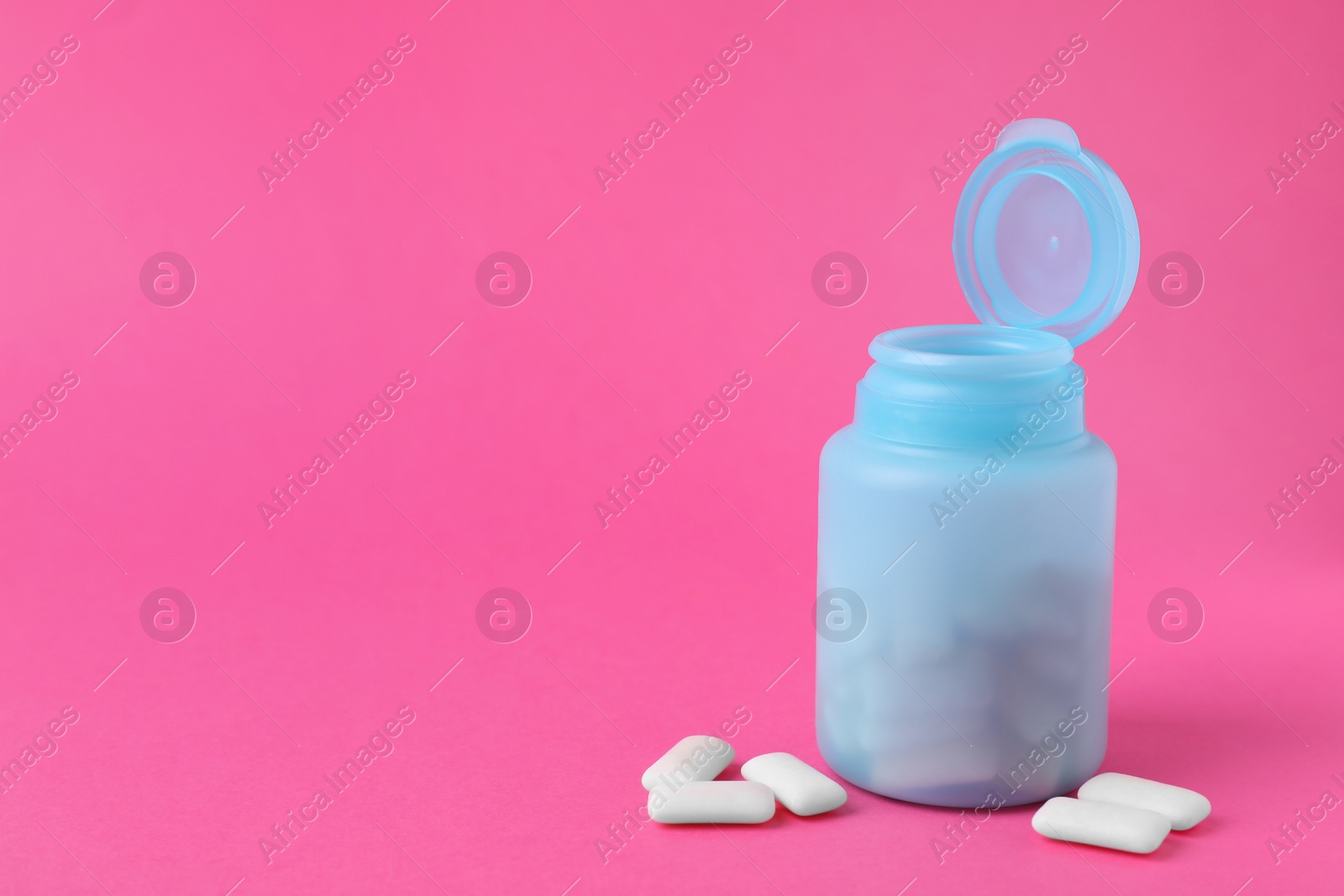 Photo of Jar with chewing gums on pink background. Space for text