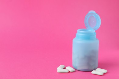 Photo of Jar with chewing gums on pink background. Space for text