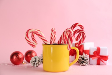Photo of Candy canes and Christmas decor on pink background