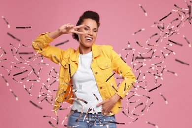 Happy woman and flying confetti on pink background