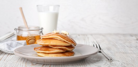 Tasty pancakes with honey and butter on table. Banner design