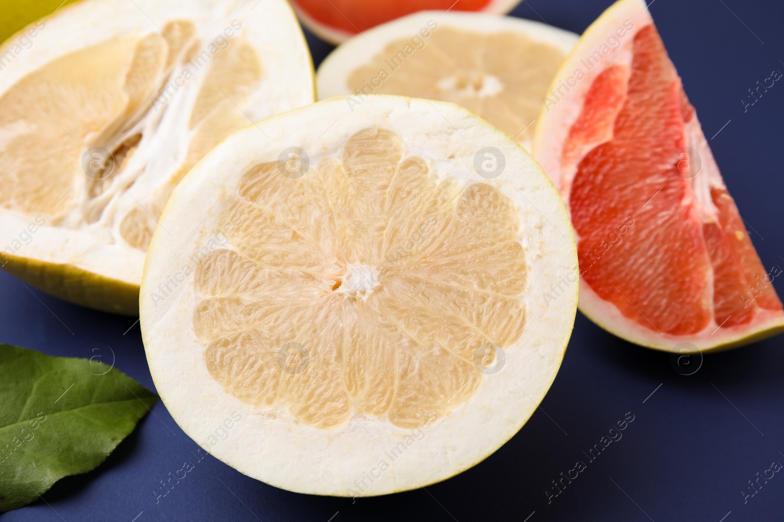 Photo of Different sorts of tasty pomelo fruits on dark blue background, closeup