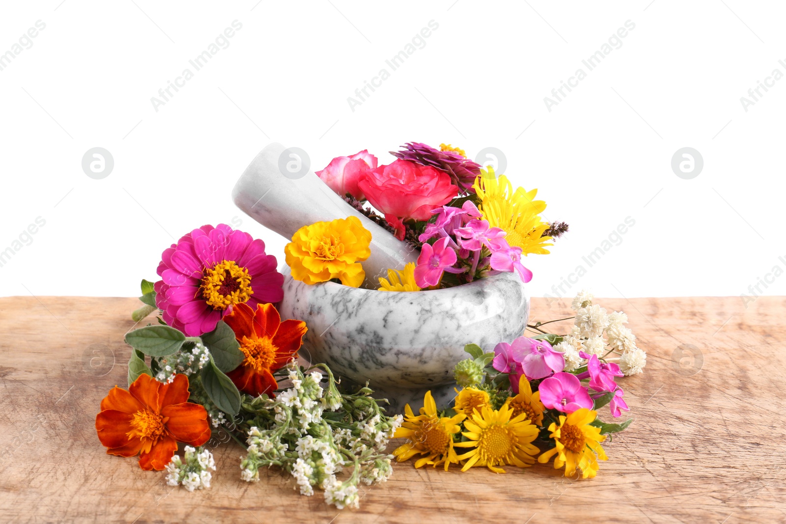 Photo of Marble mortar, pestle and different flowers on wooden table against white background