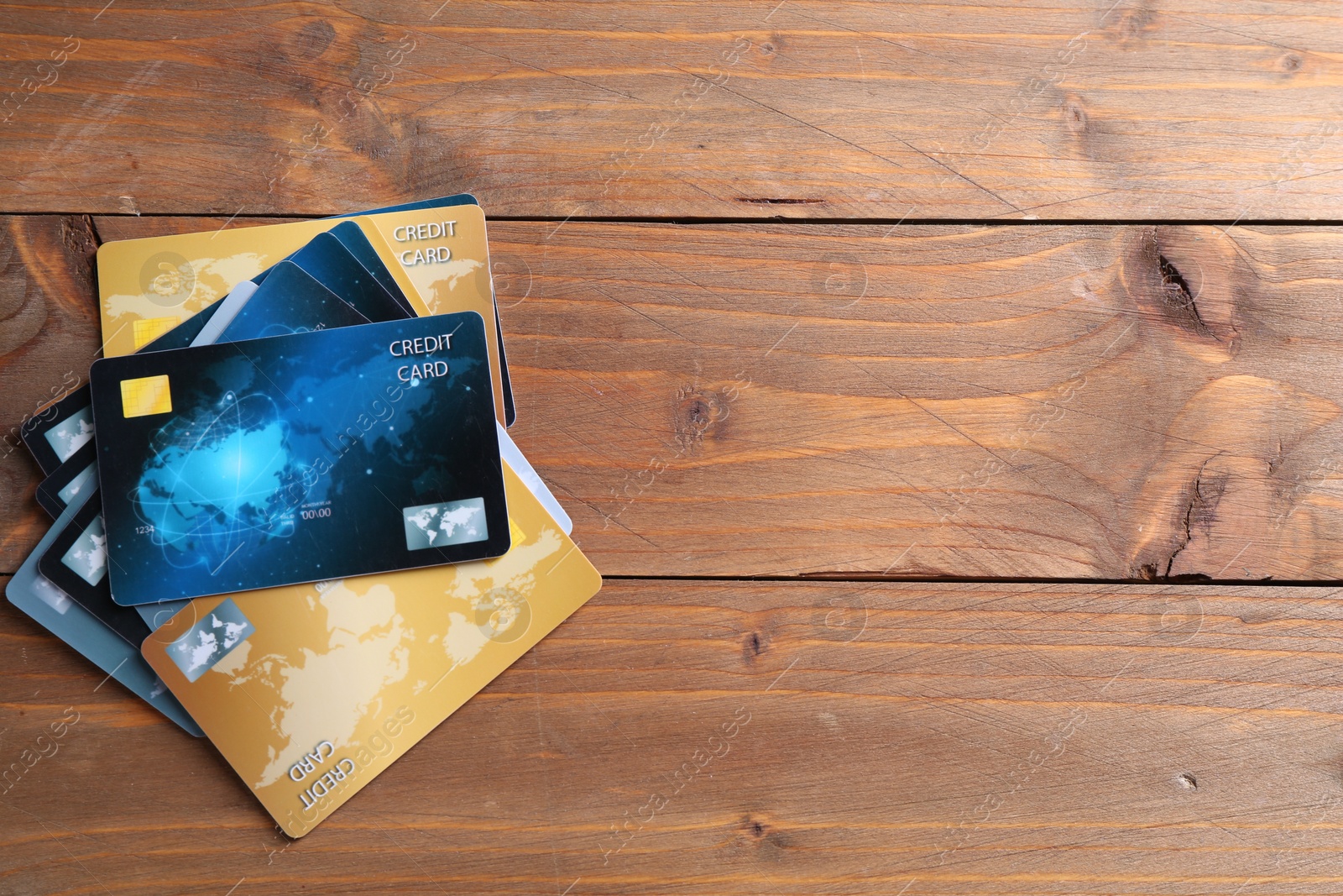 Photo of Many credit cards on wooden table, flat lay. Space for text