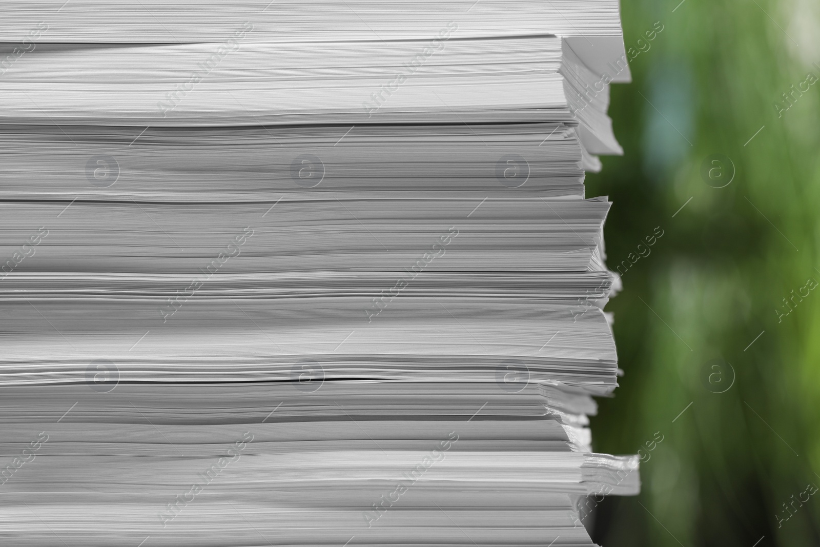 Photo of Stack of paper sheets against blurred background, closeup