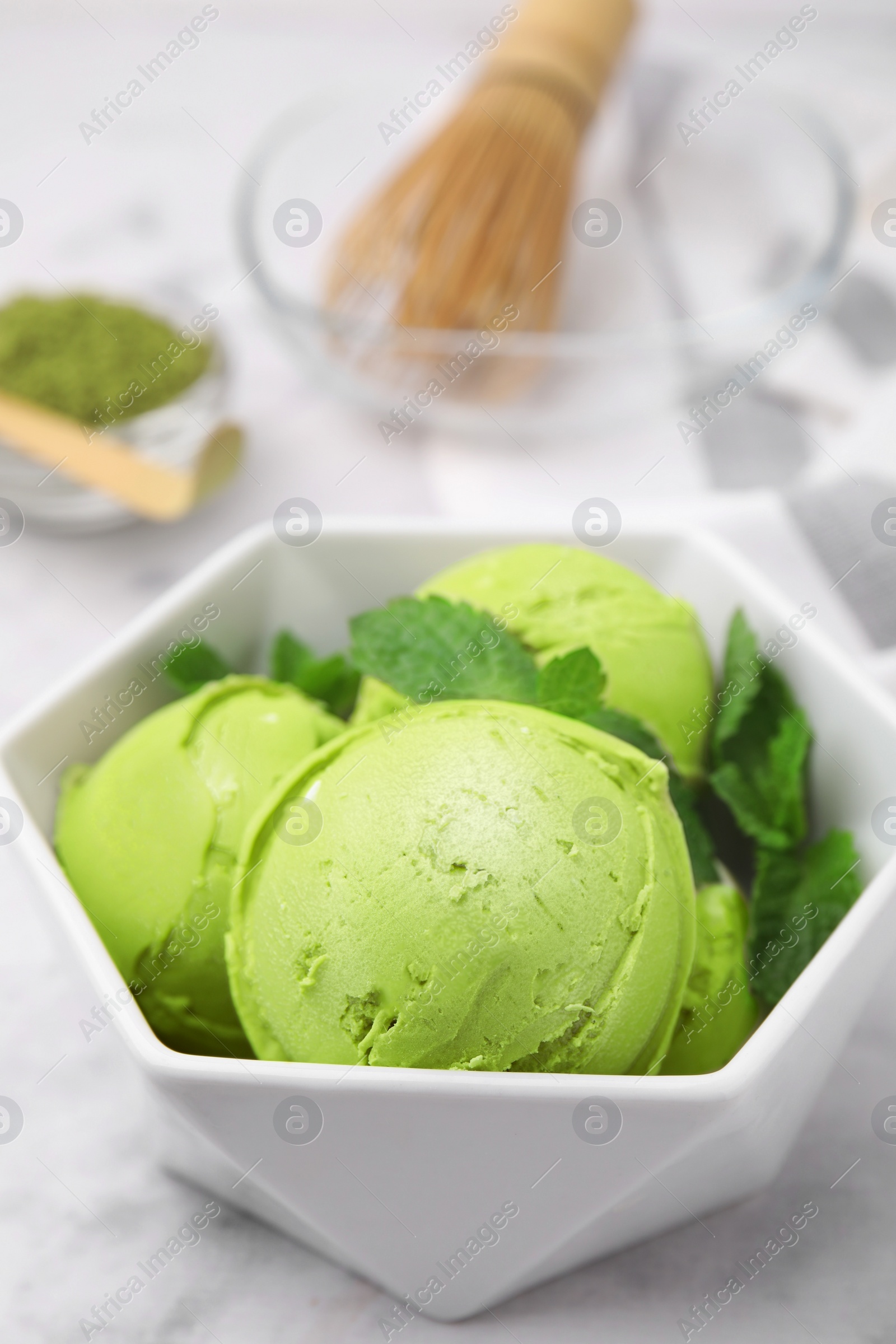 Photo of Tasty matcha ice cream in bowl on white table, closeup