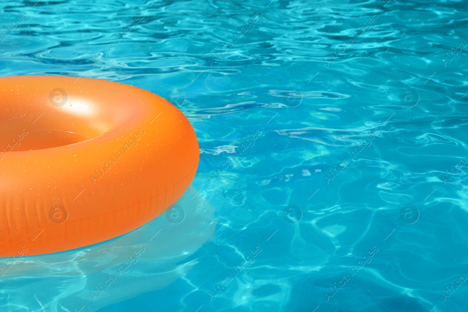 Photo of Inflatable ring floating in swimming pool on sunny day. Space for text