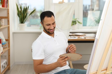 Young man painting in studio. Creative hobby