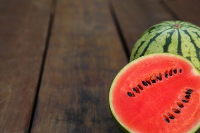 Photo of Delicious cut and whole ripe watermelons on wooden table, space for text