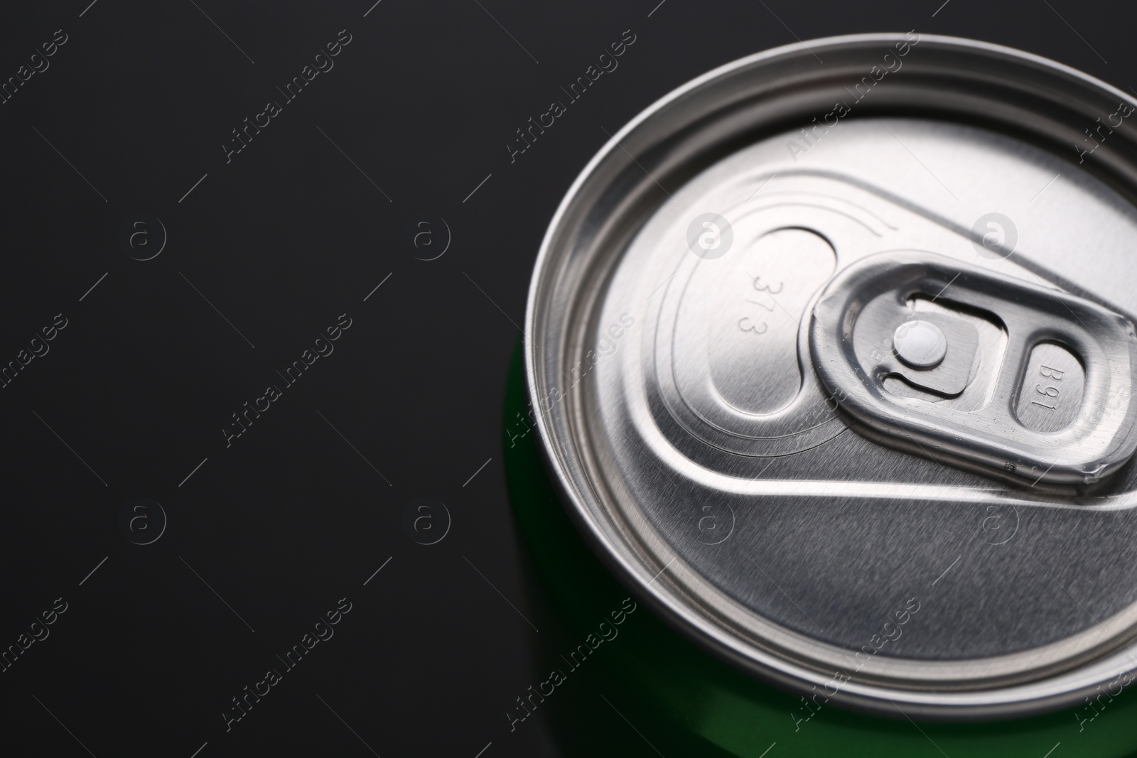 Photo of Energy drink in can on black background, closeup. Space for text