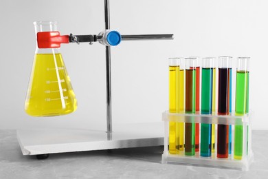 Photo of Laboratory glassware with liquids on table against white background