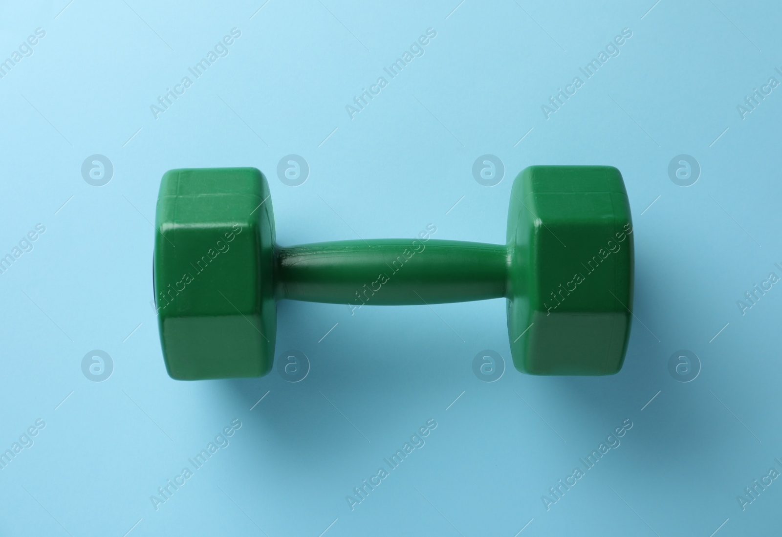 Photo of Stylish dumbbell on light blue background, top view