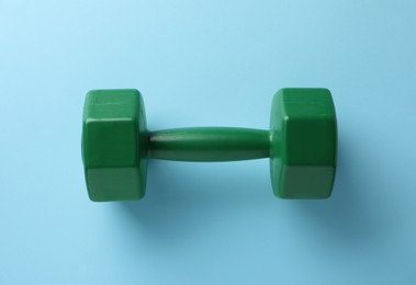Photo of Stylish dumbbell on light blue background, top view
