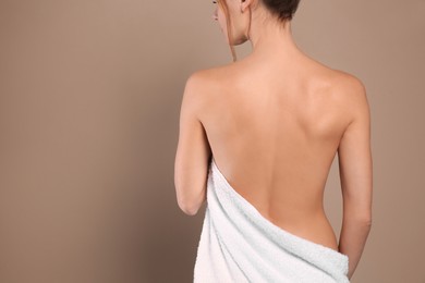 Photo of Back view of woman with perfect smooth skin on beige background, space for text. Beauty and body care