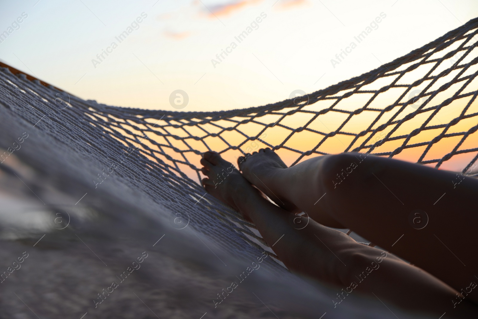 Photo of Young woman relaxing in hammock outdoors, closeup