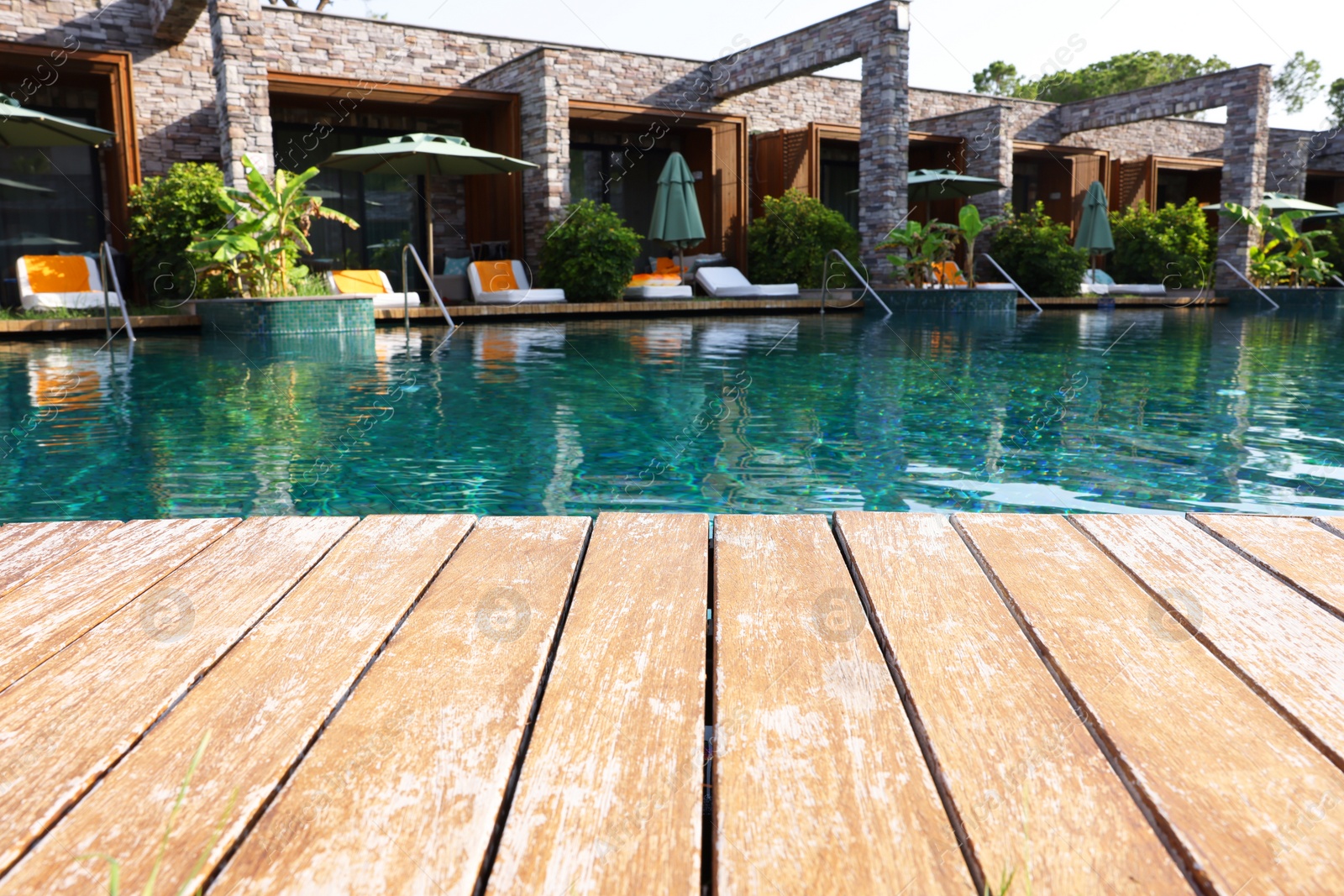 Photo of Wooden deck, swimming pool and recreational area at luxury resort