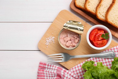 Can of conserved tuna, tomatoes and bread on white wooden table, flat lay. Space for text