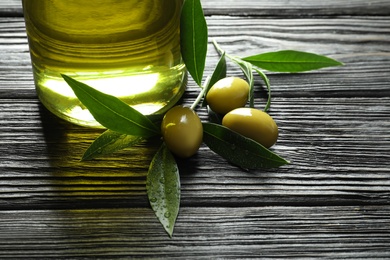 Bottle with fresh olive oil on wooden table