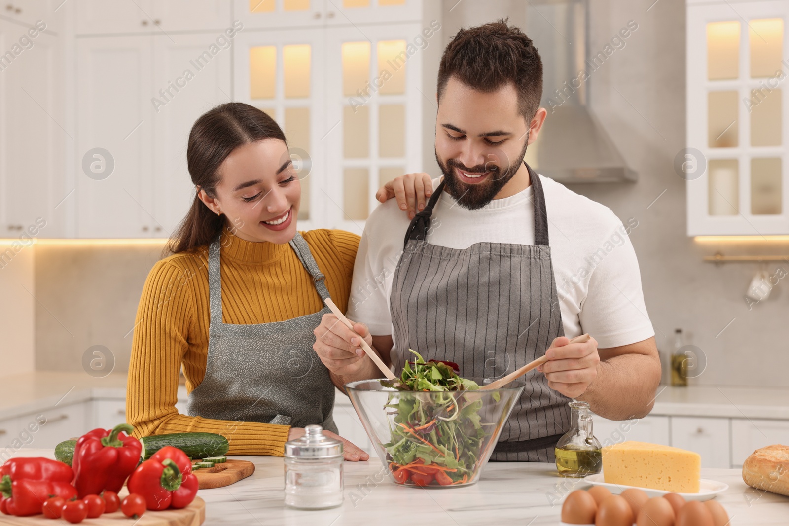 Photo of Lovely young couple cooking together in kitchen