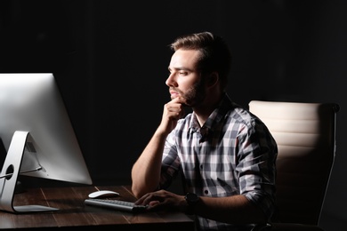 Concentrated young man working in office alone at night
