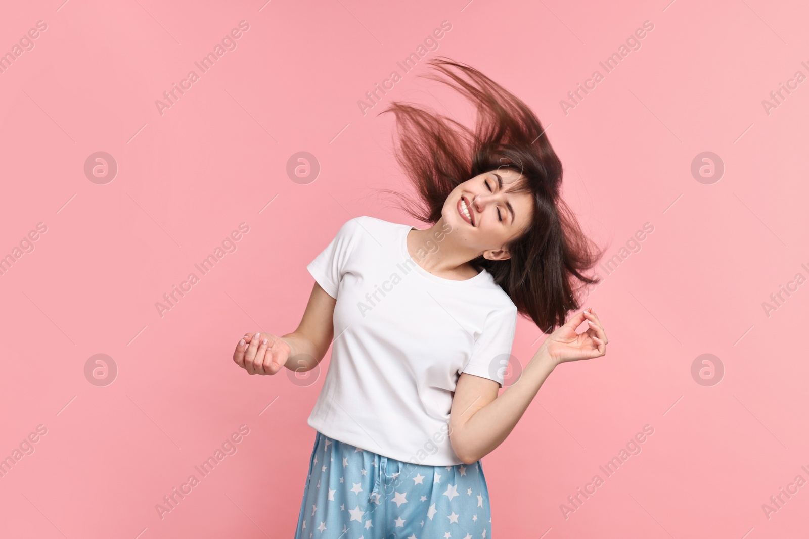 Photo of Happy woman in pyjama shaking head on pink background