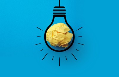 Image of Idea. Illustration of light bulb around crumpled paper ball on light blue background, top view