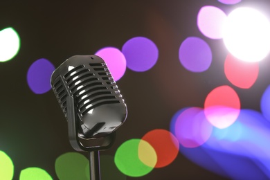 Photo of Retro microphone against festive lights, space for text. Musical equipment