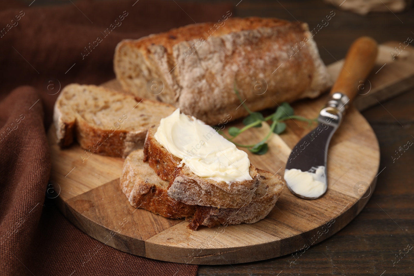 Photo of Slices of tasty bread with butter and knife on wooden table, closeup. Space for text