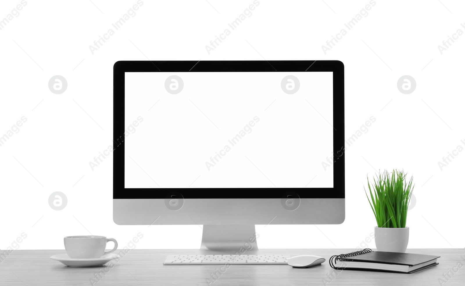 Photo of Computer, potted plant and cup of drink on table against white background. Stylish workplace