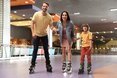 Happy family spending time at roller skating rink