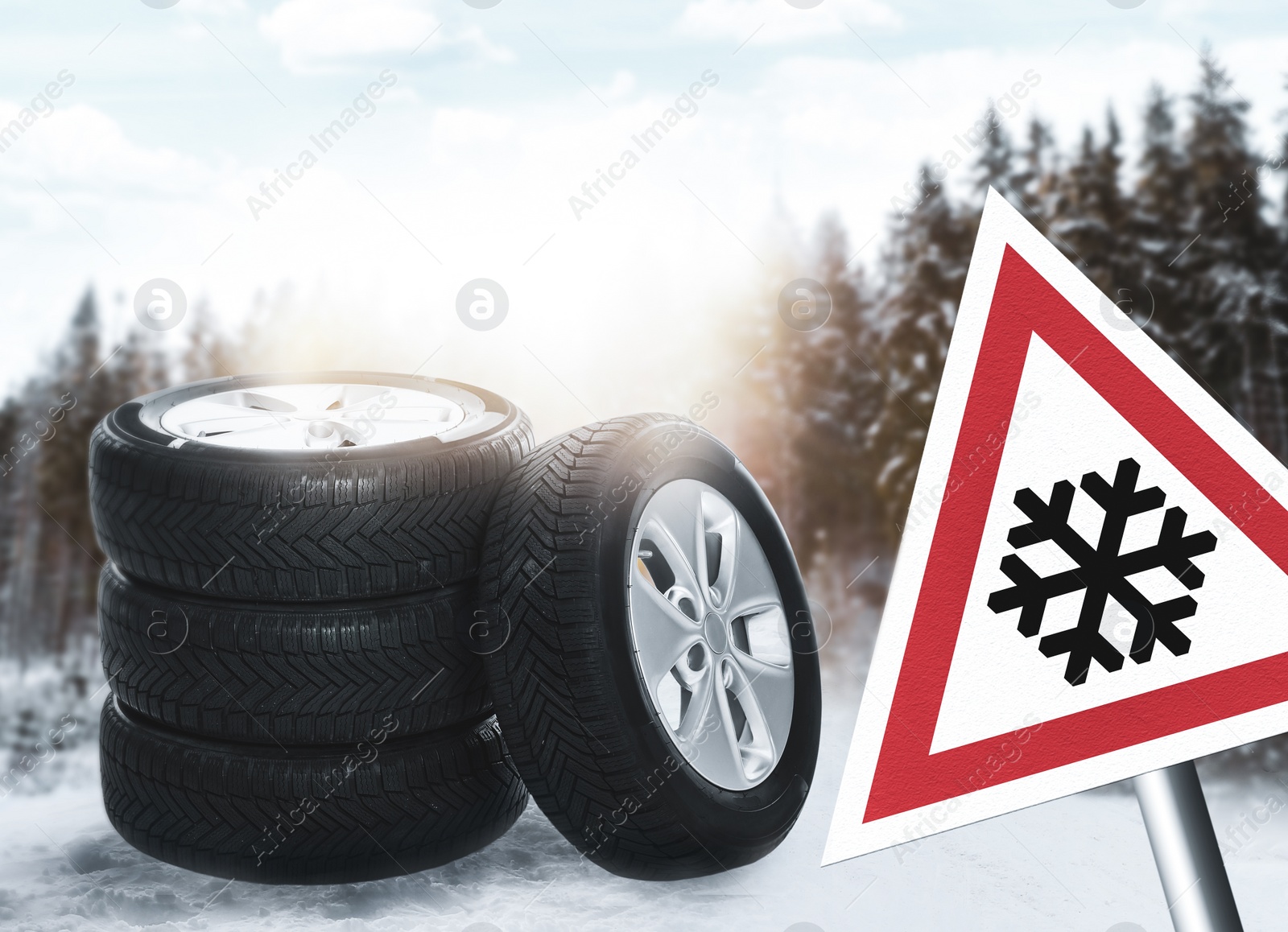 Image of Set of wheels with winter tires on snow and road sign outdoors