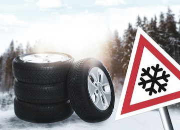 Set of wheels with winter tires on snow and road sign outdoors