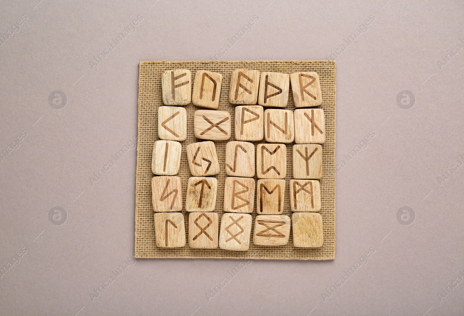 Photo of Wooden runes on light grey background, top view