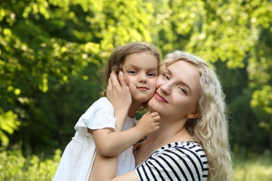 Portrait of beautiful mother with her cute daughter outdoors