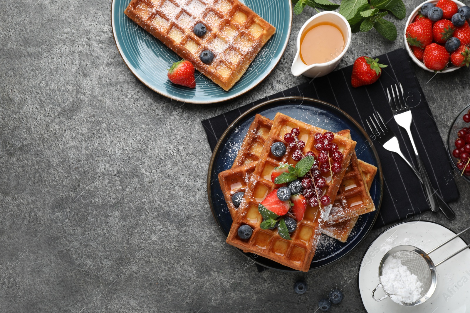 Photo of Delicious Belgian waffles with berries served on grey table, flat lay. Space for text