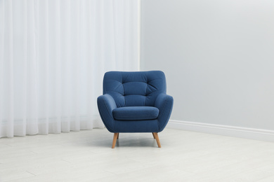 Photo of Comfortable armchair near window indoors. Stylish interior element